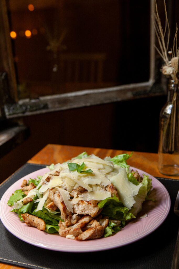 Foto prato Salada Caesar:
Alface americana acompanhada de molho caesar, parmesão em lascas, croutons e cubos de frango (100g) grelhado.