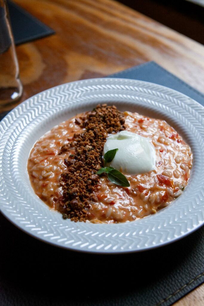 Foto prato Risoto Caprese:
Risoto cremoso com tomates frescos, mussarela de búfala e farofa de castanhas. Finalizado com manjericão.